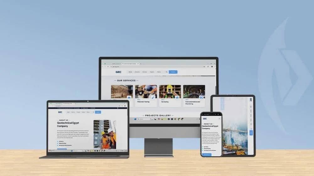 Responsive website shown on laptop, desktop monitor, tablet, and smartphone on a wooden surface.